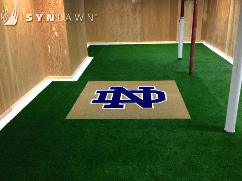 Norte Dame Prepartory logo in blue and white turf surrounded by green turf