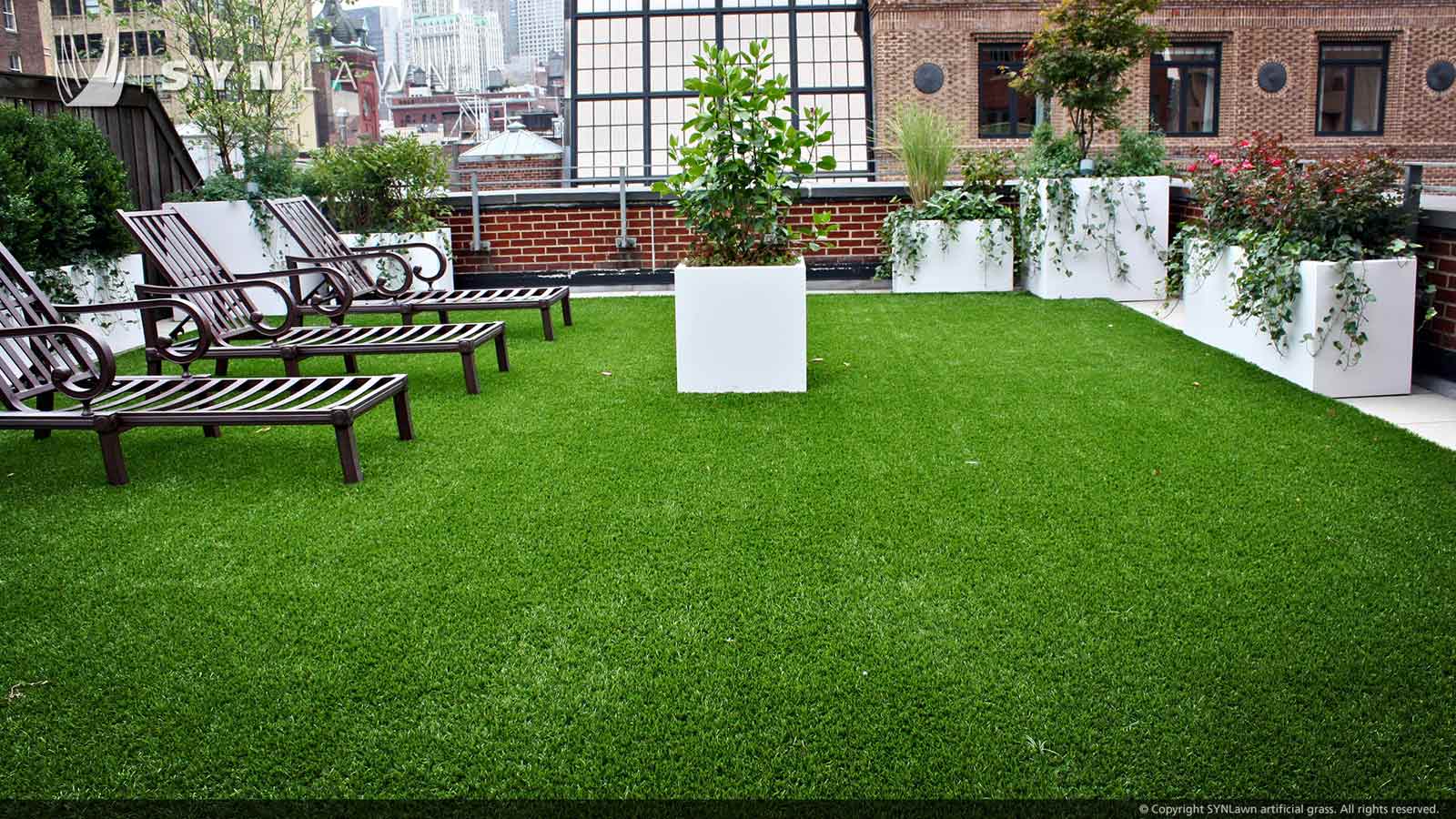 Rooftop artificial grass surrounded by large white planters in downtown Kansas City