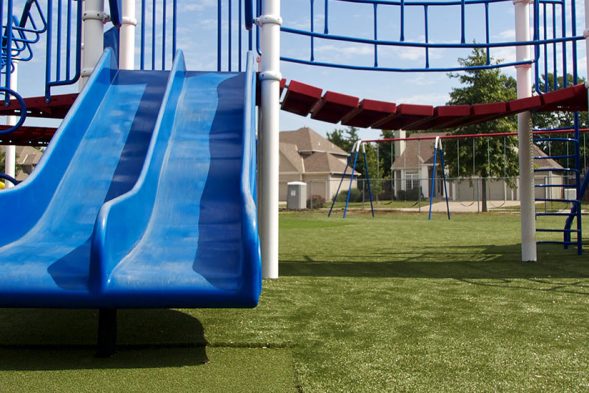playground-turf SYNLawn Tramplezone featured underneath double blue slide at Kansas playground