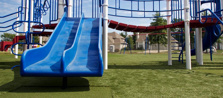 playground-turf SYNLawn Tramplezone featured underneath double blue slide at Kansas playground