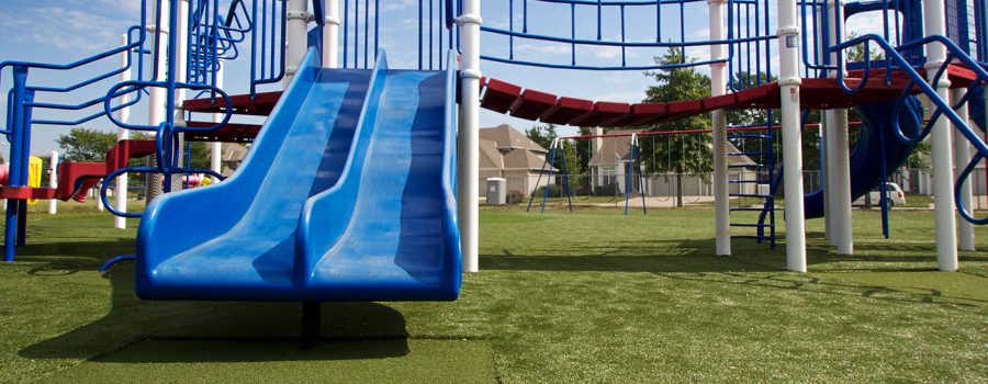 SYNLawn Tramplezone featured underneath double blue slide at Kansas playground