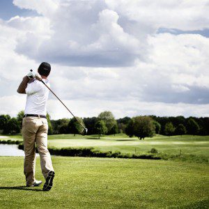 Man finishes his putt shot on large commercial golf course