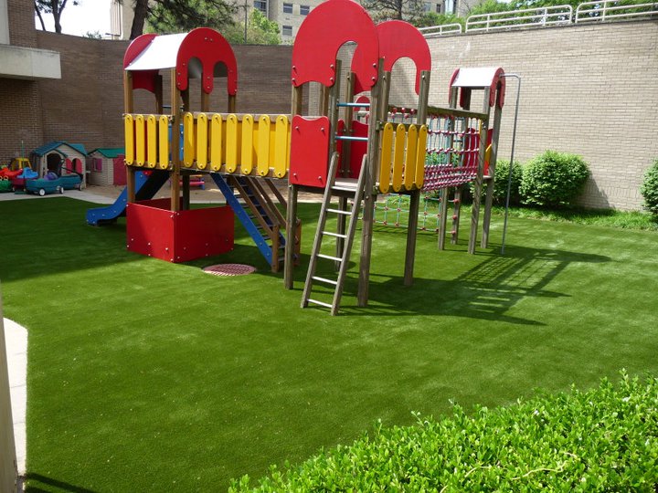 A playground on artificial turf in a backyard.